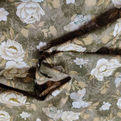 Tecido floral em verde-oliva com flores brancas e bege.
