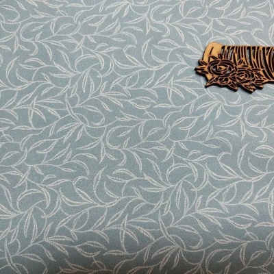 Tecido azul claro com padrão branco de folhas e carimbo de madeira decorativo