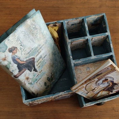 Organizador azul de madeira com compartimentos e decoração vintage sobre mesa de madeira