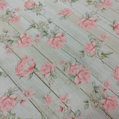 tecido floral com rosas cor de rosa sobre fundo de tábuas de madeira cinza claro