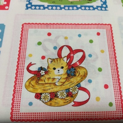 Guardanapo tecido com ilustração de gato dentro de chapéu e flores