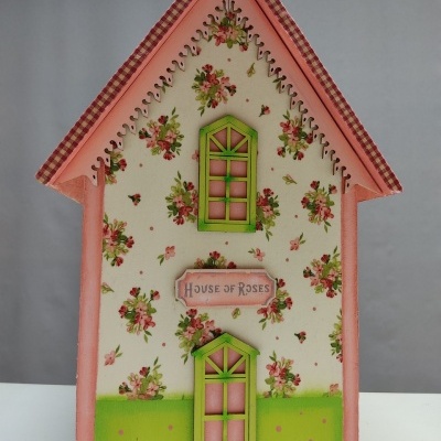 Casa decorativa de madeira com flores e texto HOUSE OF ROSES
