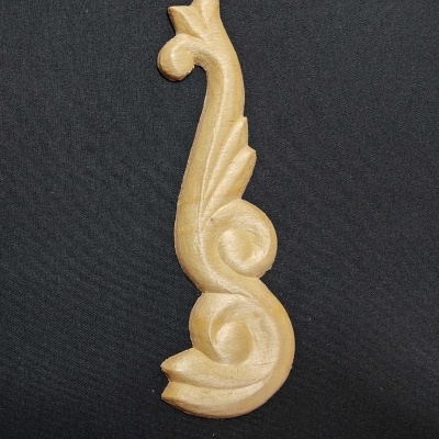 Peça decorativa esculpida em madeira clara com padrão de folhas e espirais
