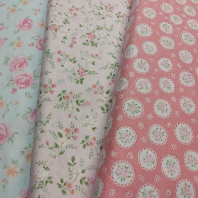 Três tecidos florais com diferentes padrões e cores