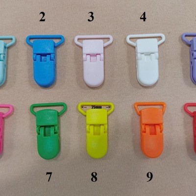 Dez presilhas plásticas coloridas numeradas organizadas em duas filas sobre fundo bege.