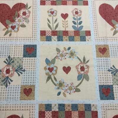 Tecido estampado com corações, flores e xadrez em tons vermelhos, azuis e beges