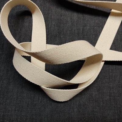 Fita de tecido bege claro sobre superfície de tecido escuro