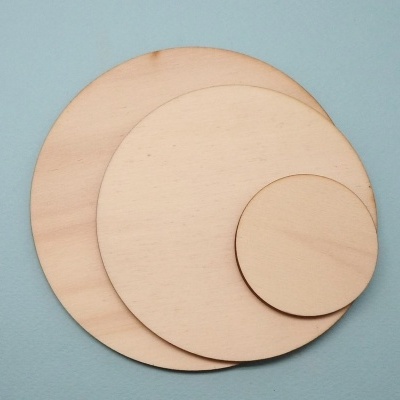 Três círculos de madeira de diferentes tamanhos sobre fundo azul claro