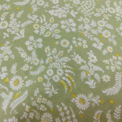 Tecido verde claro com flores brancas e detalhes amarelos