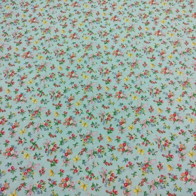 Tecido azul claro com padrão floral pequeno colorido