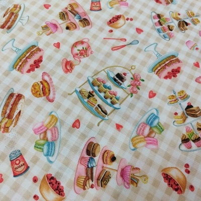 Tecido padrão bege com ilustrações coloridas de bolos e doces