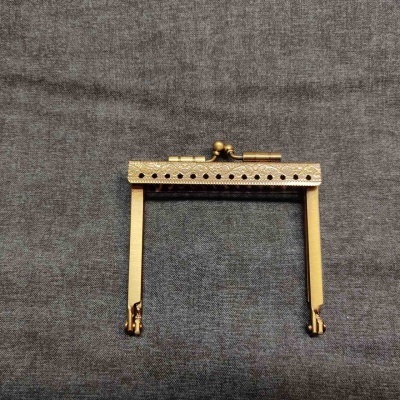 Moldura metálica dourada para carteira sobre tecido cinza