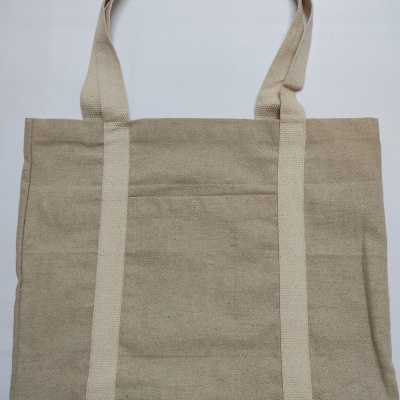 Mala de tecido bege com duas alças largas de cor clara sobre fundo branco