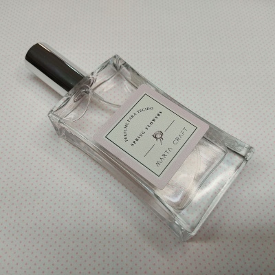 Frasco de perfume Maria Craft Spring Flowers sobre tecido branco com pontos cor-de-rosa