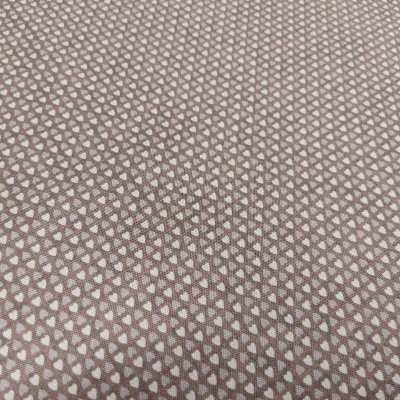 Tecido castanho com padrão de pequenos corações brancos