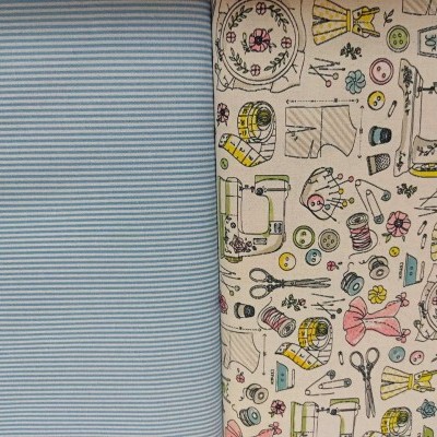 Dois tecidos lado a lado, riscas azuis e brancas e padrão colorido com temas de costura.