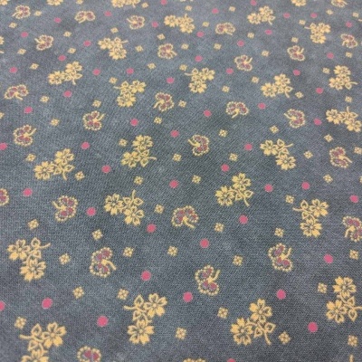 Tecido azul-escuro com padrão de flores amarelas e pontos vermelhos