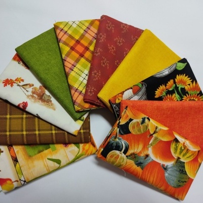 Nove tecidos coloridos e com diversos padrões de outono arranjados em forma de leque