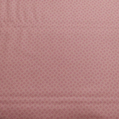 Tecido cor-de-rosa com pequenos círculos vermelhos repetidos