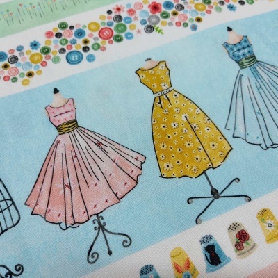 Tecido com padrão de manequins e vestidos vintage coloridos em fundo azul claro.