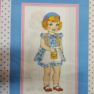 Painel de tecido azul claro com ilustração de menina em vestido azul com avental branco