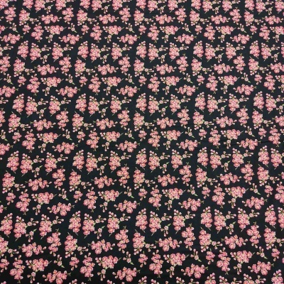 Tecido floral com flores cor-de-rosa e bege sobre fundo preto