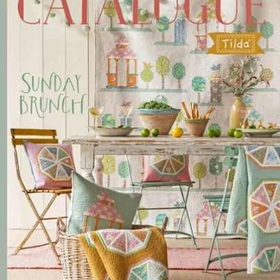 Capa de catálogo decorativo com têxteis coloridos e mesa de jantar