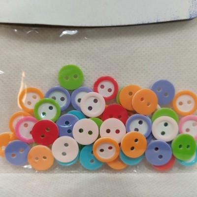 Pacote de botões coloridos redondos com dois furos dentro de saco plástico