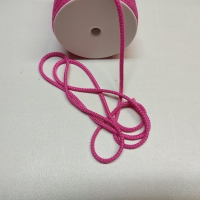 Rolo de fita rosa sobre superfície branca