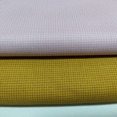 Tecidos dobrados bege claro e amarelo mostarda com padrão texturizado