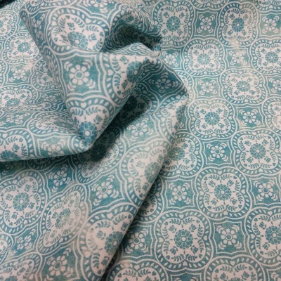 Tecido azul esverdeado e branco com padrão floral e circular