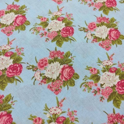 tecido azul claro com padrão floral rosa, branco e verde