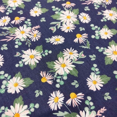 Tecido azul escuro com padrão de margaridas brancas e folhas verdes