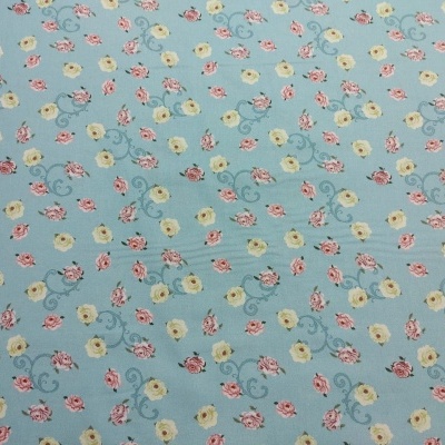 Tecido azul claro com flores amarelas e rosas pequenas