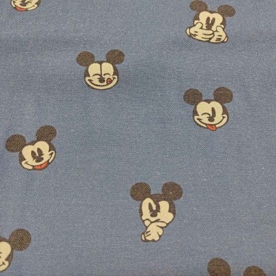 Tecido cinzento com padrões de rostos de personagens parecidos com Mickey Mouse.