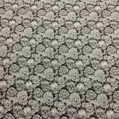 Tecido estampado com padrão de caveiras brancas sobre fundo preto