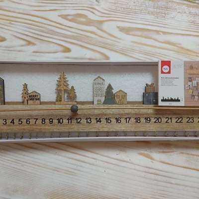 Calendário de advento em madeira com decoração natalícia e números de 1 a 24.