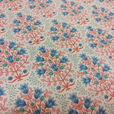 Tecido com padrão floral azul, rosa e vermelho sobre fundo branco