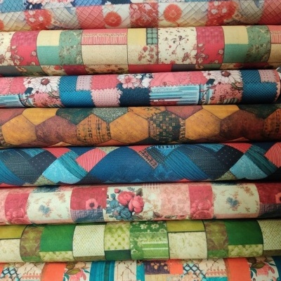 Rolos de tecidos coloridos com padrões variados empilhados