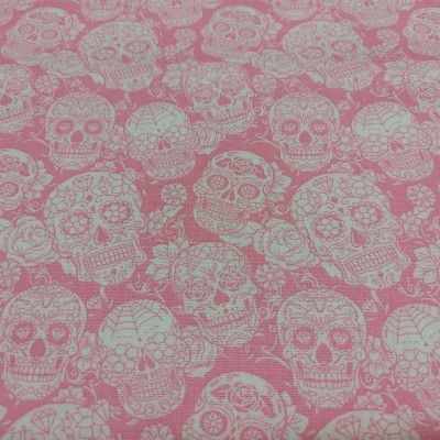 Tecido rosa com padrão de caveiras decoradas brancas