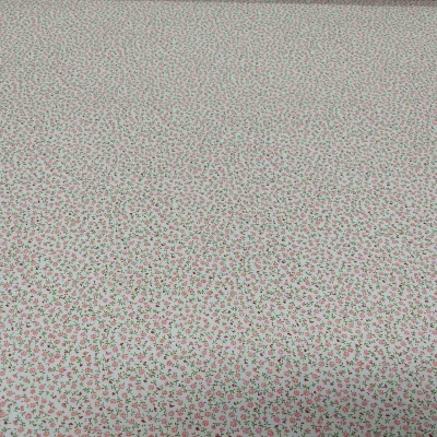 Tecido branco com padrão floral pequeno em cor de rosa e verde