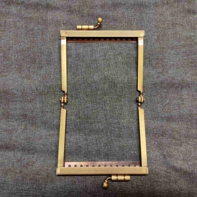 Estrutura retangular dourada em metal sobre tecido cinza escuro