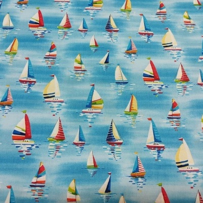 Tecido estampado com pequenos veleiros coloridos em fundo azul