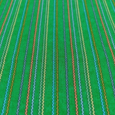 Tecido verde com riscas verticais multicoloridas e padrões ondulados