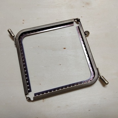 Estrutura metálica quadrada com parafusos de aperto sobre fundo branco