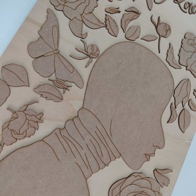 Placa decorativa de madeira com perfil humano e motivos florais e de borboletas