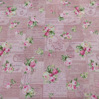Tecido estampado vintage com flores rosas, texto em francês e desenhos decorativos em tons de rosa e bege.