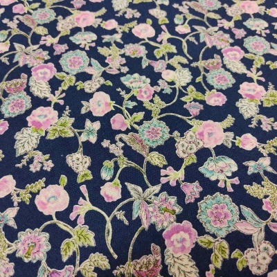 Tecido azul com padrão floral colorido com rosas, verdes e lilás