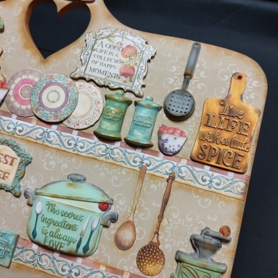 Placa decorativa com utensílios de cozinha e textos inspiradores em inglês.