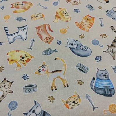 Tecido bege com padrão de gatos coloridos, peixes, ossos e latas de comida para gato.